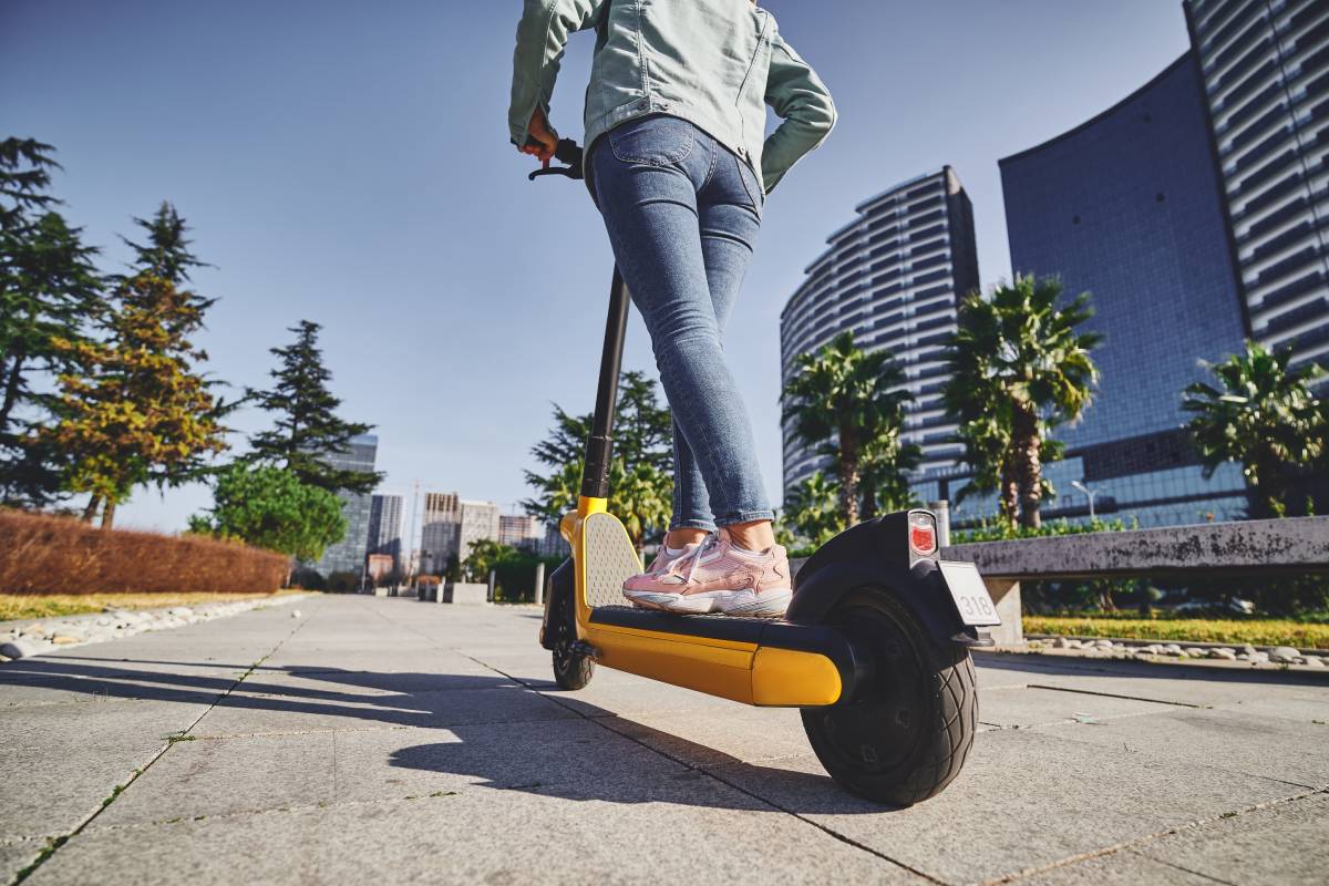 Jeune femme sur une trottinette électrique couvert par une assurance