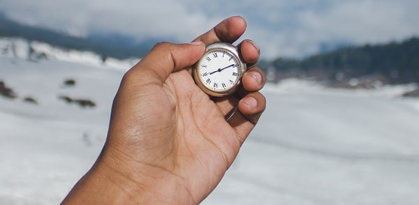 Une personne tenant une horloge dans sa main