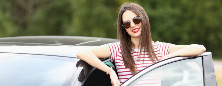 Une jeune femme jeune conductrice auto qui assure sa voiture