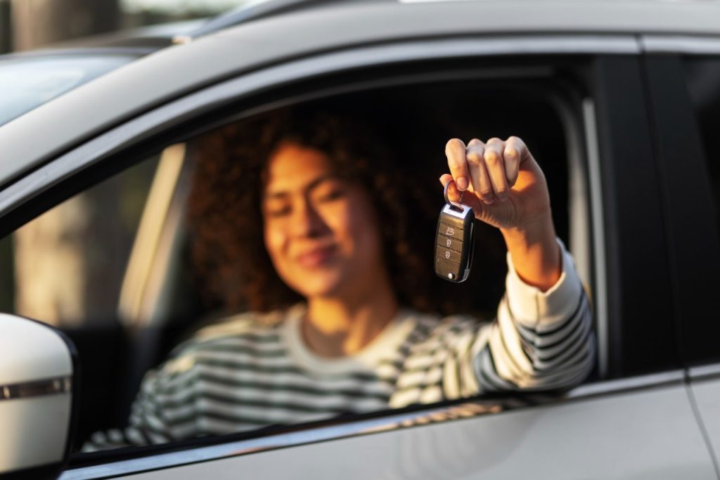 Une femme dans une voiture d'emprunt avec une assurance provisoire